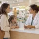 Un parent accompagné de son enfant échange avec une pharmacienne au comptoir.