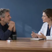 Un homme échange avec une professionnelle de santé dans un espace de consultation.
