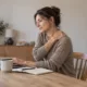 Une femme assise à son bureau pose une main sur son épaule.